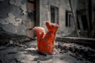 Orange felt squirrel on a crumbling windowsill in chernobyl